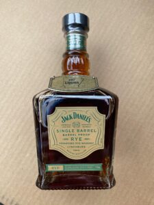 Jack Daniel’s Single Barrel Barrel Proof Rye Tennessee rye whiskey bottle (750 mL) with green label, photographed on a tan background.