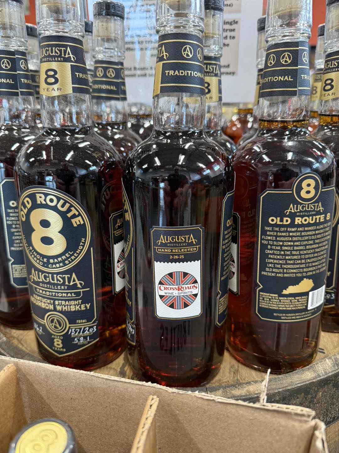 Close-up of Augusta Distillery “Old Route 8” 8-year Kentucky straight bourbon whiskey bottles on a store shelf, including a hand-selected Crossroads Wine & Spirits bottle.