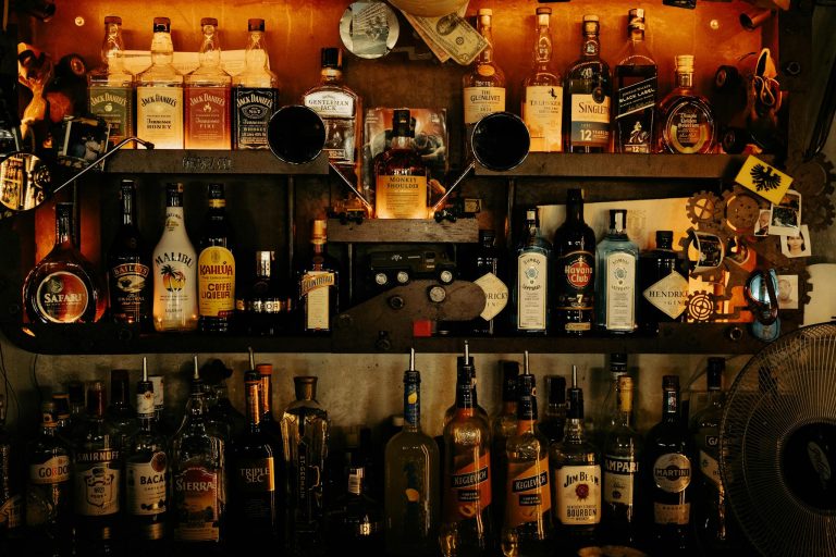An indoor bar with an eclectic display of various liquor bottles on shelves, creating a warm ambiance.