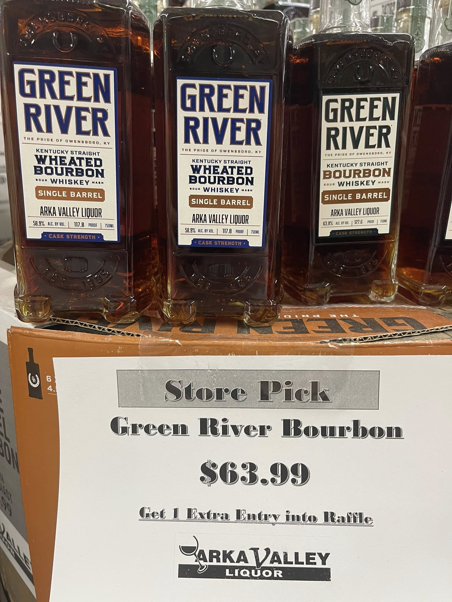 Three Green River wheated bourbon bottles above a store sign reading “Store Pick Green River Bourbon $63.99” with a “Park Valley Liquor” logo at the bottom.