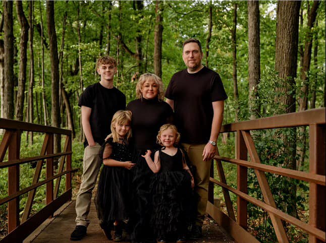 Family portrait of George Shanley with immediate family smiling together in a casual outdoor setting.