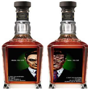 Front view of two Jack Daniel’s Barrel Proof bottles side by side, each showing a custom illustrated label: one says ‘Heads…you live’ with a suited face, the other says ‘Tails…you die’ with a scarred face; collaboration text includes 107 Liquor, Spa City Bourbon, and Bourbon Club of Arkansas.