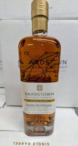 Front view of a Bardstown Bourbon Company Single Barrel Kentucky straight bourbon whiskey bottle with amber liquid, gold foil neck, and label reading ‘Bourbon Club of Arkansas,’ ‘Rickhouse E1, Floor 1,’ 55.7% ABV, 111.4 proof, 750 ml, photographed against stacked white Bardstown Bourbon Company boxes.