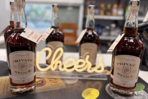 Premium Private Stock bourbon bottles on countertop, Cheers decor, liquor shop setting.