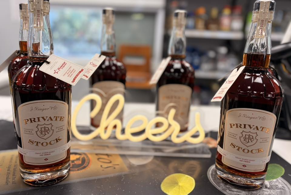 Premium Private Stock bourbon bottles on countertop, Cheers decor, liquor shop setting.