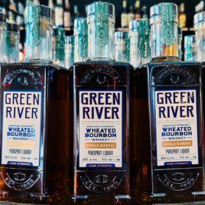 Close-up of Green River Kentucky Straight Wheated Bourbon whiskey bottles (single barrel, cask strength) lined up on a liquor store shelf.